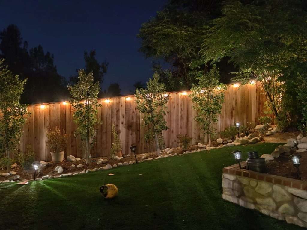 Redwood fence board on board, stained with Postmaster galvanized steel posts and decorative lightning on a slope | Thousand Oaks CA