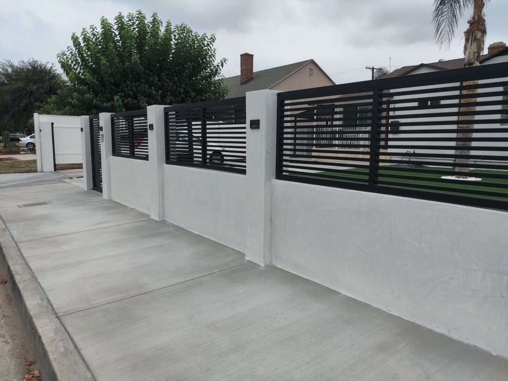 Steel Wall toppers on block wall with stucco. Powder Coated finish. 1in slats with 1in gap.